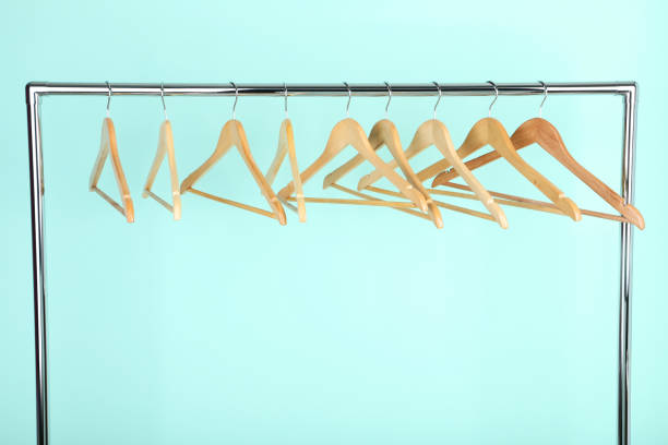 istock Wooden hangers hanging on mint background 1127490335