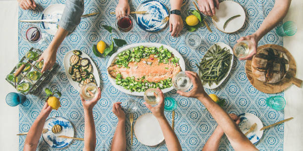 istock Mediterranean style dinner with cooked salmon and drinks, wide composition 1127492171