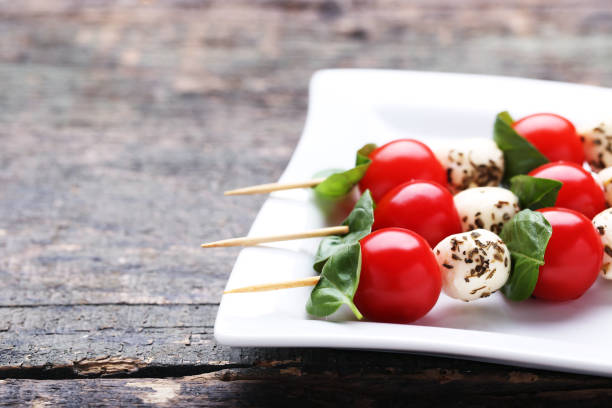 istock Sticks with mozzarella, tomatoes and basil leafs on gray wooden table 1127492382