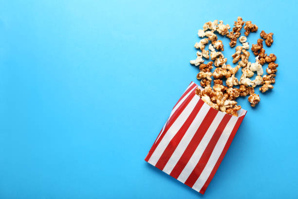 istock Caramel popcorn in paper bag on blue background 1127493409