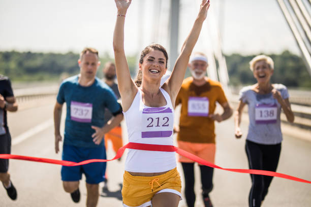 istock Happy female marathon runner celebrating victory while crossing the finish line. 1127493862