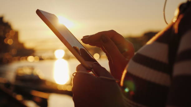 mains d’une femme avec un smartphone sur le fond d’une jetée avec yachts au coucher du soleil - passenger ship flash photos et images de collection