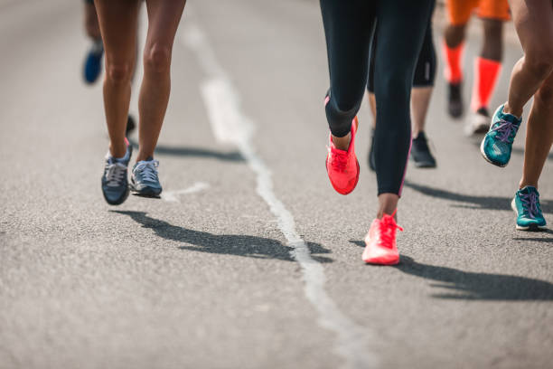 группа неузнаваемых спортсменов, бегая марафон по дороге. - road running стоковые фото и изображения