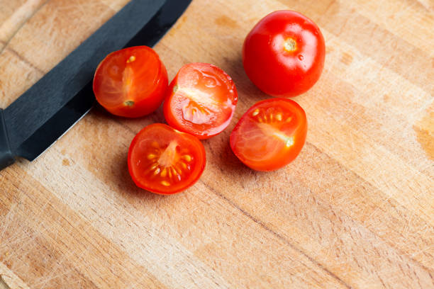 istock Black ceramic knife on a wooden Board with cherry tomatoes. 1127495596