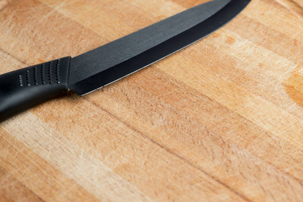 istock Black ceramic knife on wooden Board. 1127495604