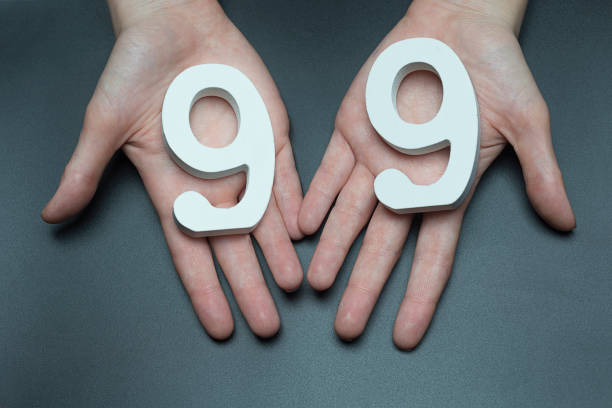 istock To female hands the number ninety-nine. 1127495984