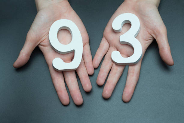 istock To female hands the figure of ninety-three. 1127496608
