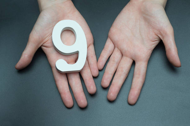 istock To female hands the number nine. 1127497173