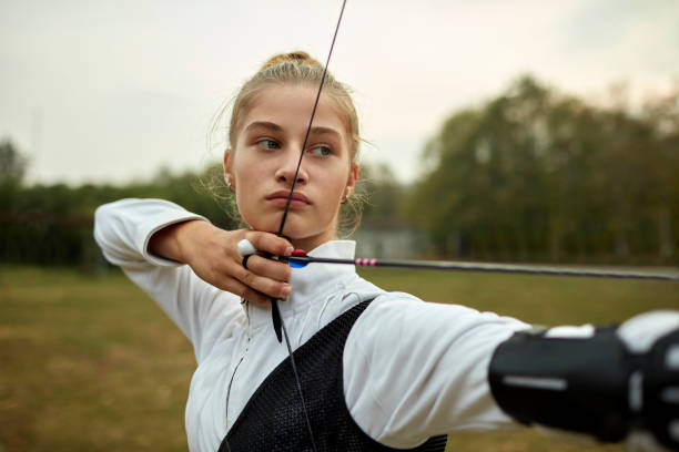 bogenschießen-mädchen - archery bow arrow women stock-fotos und bilder
