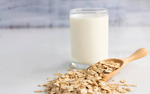 우유와 흰색 테이블에 숟가락에 귀리의 유리. 그는 영양이 풍부한 식품 단백질 및 섬유와 관련 된. - granola cereal breakfast stack 뉴스 사진 이미지