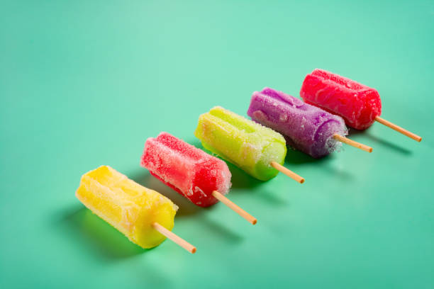 istock multi-color popsicles line up on green background with copy space 1127498461