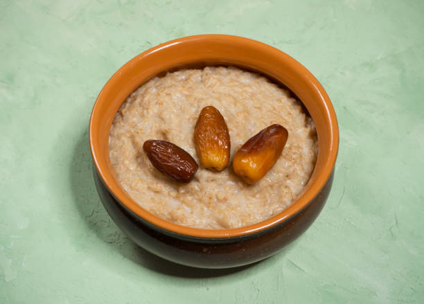 istock Oatmeal with dates on the green table. 1127499337