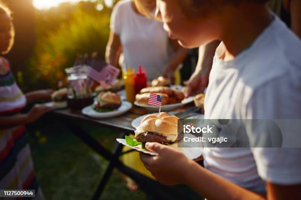 Multi Generations Family Celebrating 4th Of July Stock Photo - Download Image Now - Fourth of July, Burger, Picnic