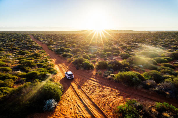 Driving off-road in Western Australia at sunset Driving off-road in Western Australia at sunset, aerial view. Francois Peron National Park australian bush stock pictures, royalty-free photos & images