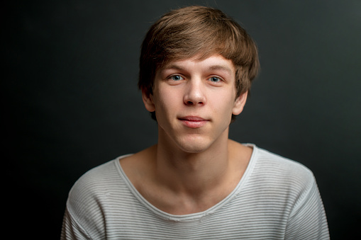 Studio portrait of an attractive 20 year old man on gray background