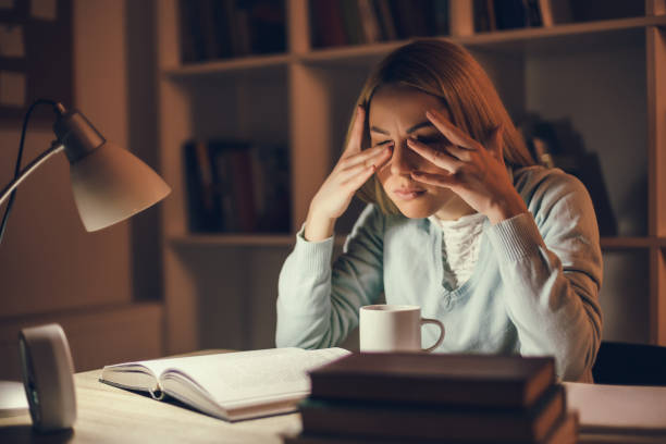 Student learning at home Tired student is learning at home. She is rubbing her eyes. tired after work stock pictures, royalty-free photos & images