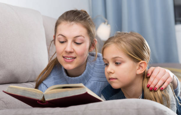 istock Mother and daughter reading book 1127503959