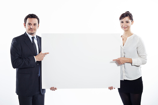 Businessman and businesswoman holding a white blank sign together.