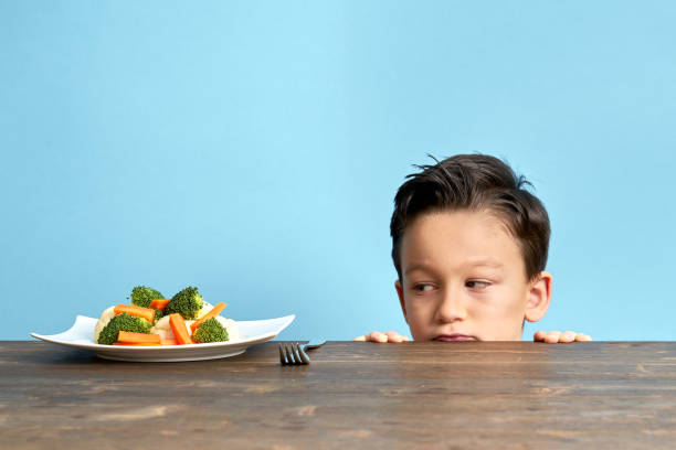 dziecko jest bardzo niezadowolone z konieczności jedzenia warzyw. - cute disgust carrot caucasian zdjęcia i obrazy z banku zdjęć