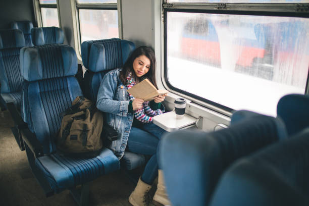 istock Women reading book on the train 1127507750