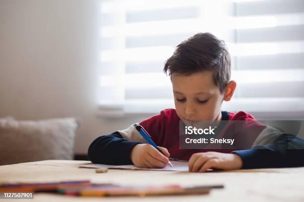 Junge Zu Hause Machen Hausaufgaben Schreiben Von Briefen Mit Bunten Stiften Stockfoto und mehr Bilder von Porträt