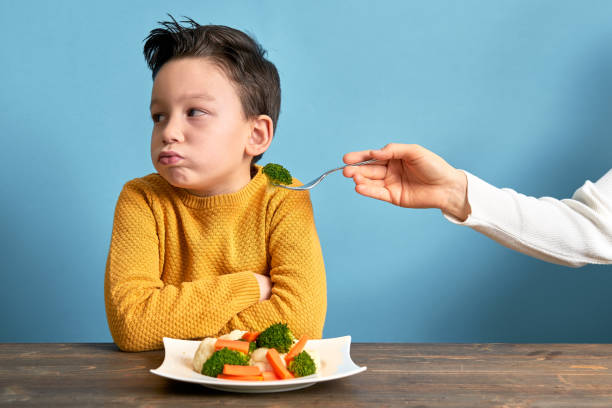 dziecko jest bardzo niezadowolone z konieczności jedzenia warzyw. - cute disgust carrot caucasian zdjęcia i obrazy z banku zdjęć