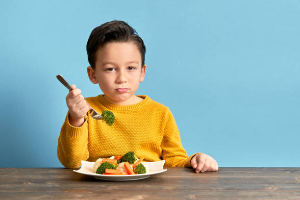 istock Child is very unhappy with having to eat vegetables. 1127508092