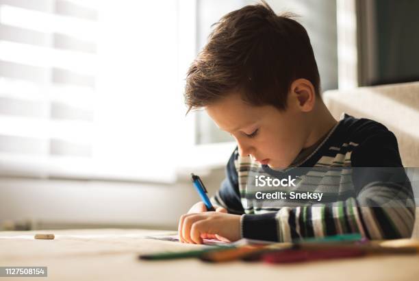 Junge Zu Hause Machen Hausaufgaben Schreiben Von Briefen Mit Bunten Stiften Stockfoto und mehr Bilder von Akademisches Lernen