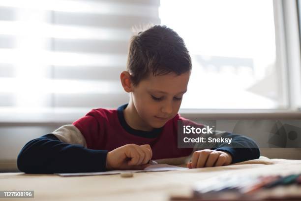 Junge Zu Hause Machen Hausaufgaben Schreiben Von Briefen Mit Bunten Stiften Stockfoto und mehr Bilder von Akademisches Lernen