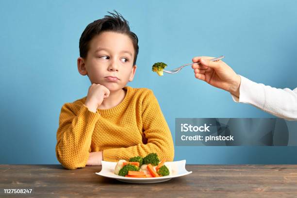Child Is Very Unhappy With Having To Eat Vegetables Stock Photo - Download Image Now
