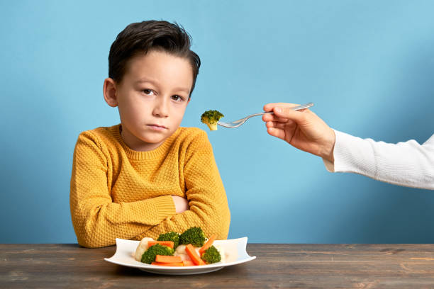 dziecko jest bardzo niezadowolone z konieczności jedzenia warzyw. - cute disgust carrot caucasian zdjęcia i obrazy z banku zdjęć