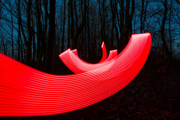 istock Red Neon light trails in a winter forest at dusk. 1127508318
