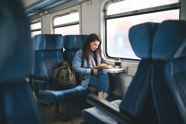 istock Women reading book on the train 1127508344