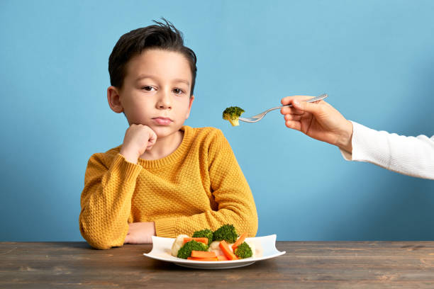 istock Child is very unhappy with having to eat vegetables. 1127509015