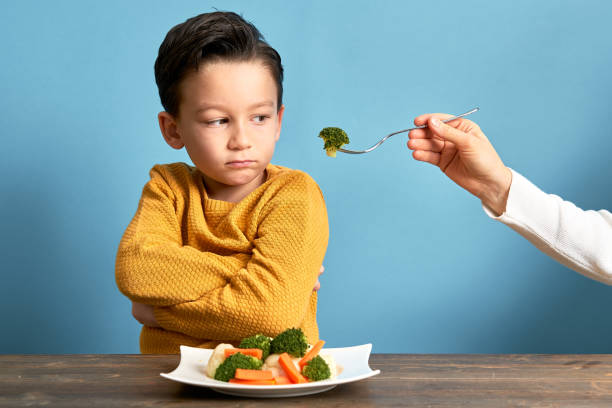 istock Child is very unhappy with having to eat vegetables. 1127509017