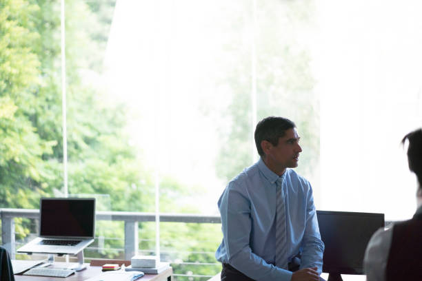 istock Businessman sitting at desk by window in office 1127509552