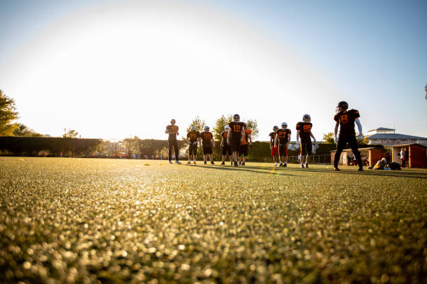 Coach (20s) with boys (9 years) playing sports.