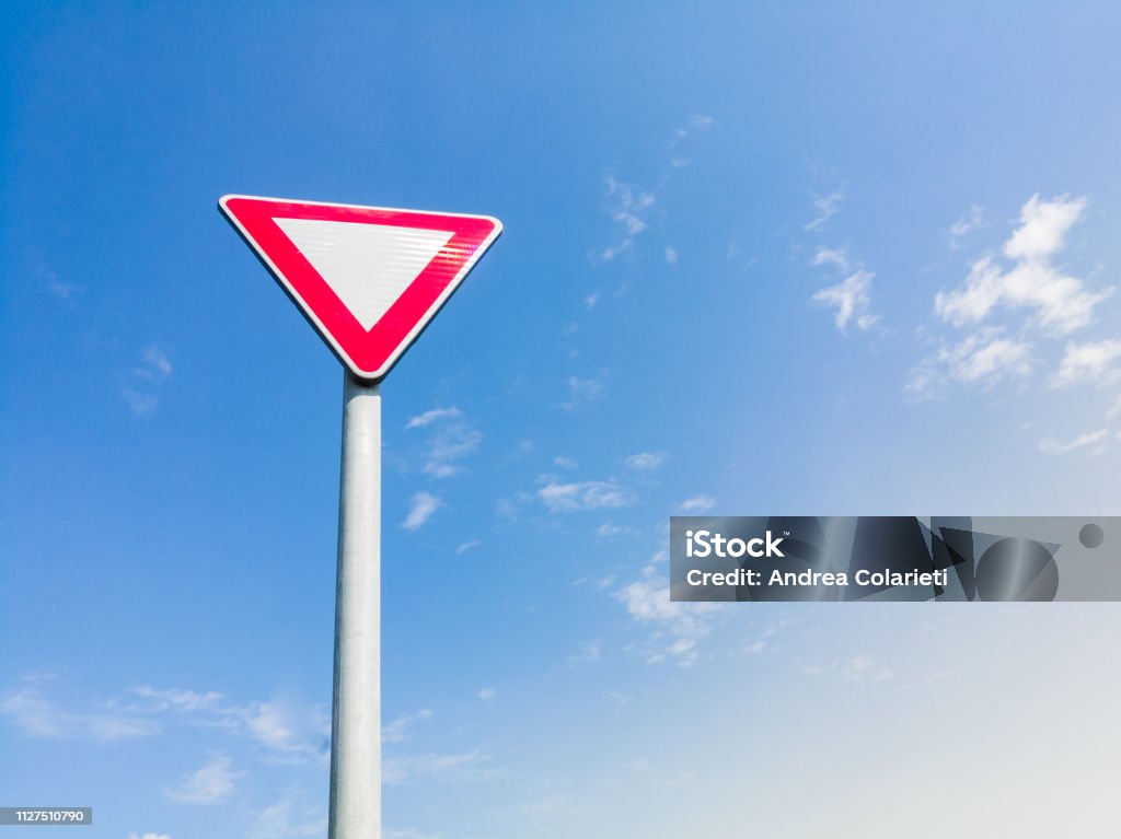 Arka plan olarak mavi gökyüzü ile metalik kutup öncelik veren bir üçgen yol vermek yolu işaret - Royalty-free Yol İşaretleri Stok görsel
