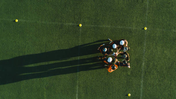 Drone point view of players huddling Rugby Team before  Match At Stadium, huddling, directly above american football stadium stadium sport outdoors stock pictures, royalty-free photos & images