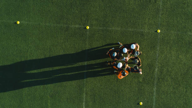 drone point view of players huddling - sports team team teamwork togetherness imagens e fotografias de stock
