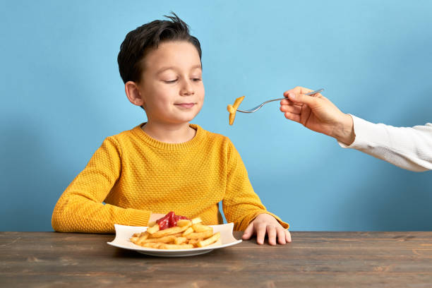 istock Child is eating french fries. 1127511290