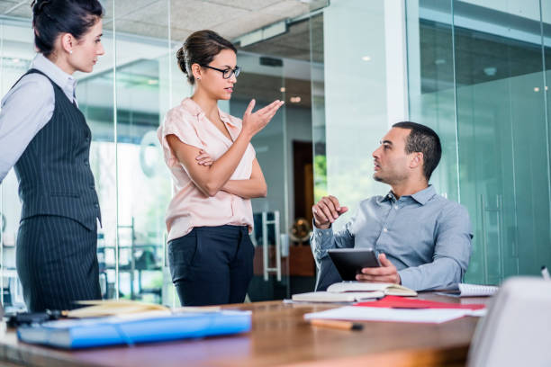 istock Businesswoman talking to colleague at table 1127512640