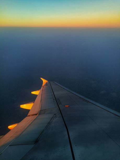 istock airplane jet wing. dramatic sky from airplane window seat. dawn on air. 1127515699