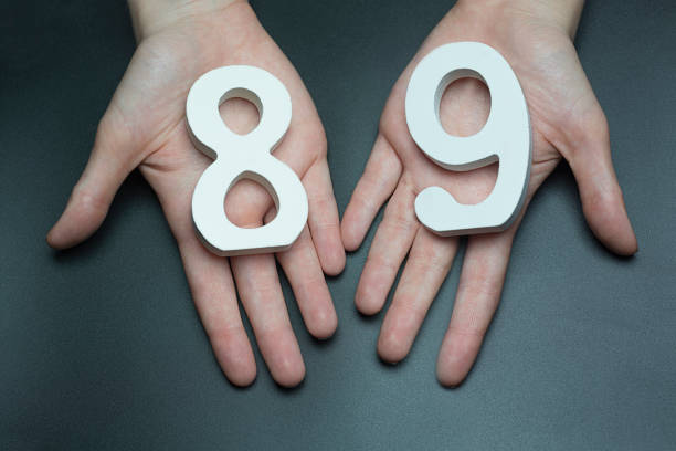 istock To female hands the figure of eighty-nine. 1127515780