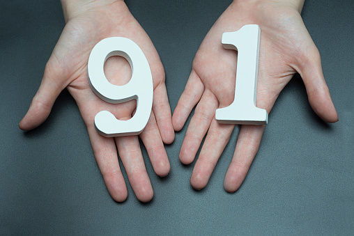 On a black background, female hand with numbers ninety-one.