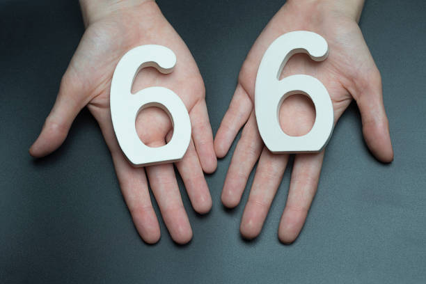 istock To female hands the number sixty-six. 1127517689