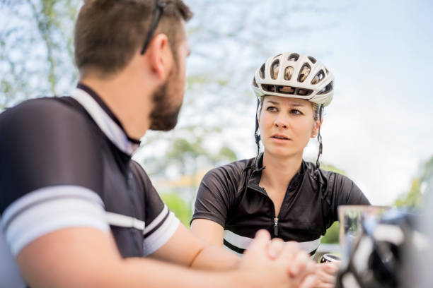 istock Female cyclist looking at man in yard 1127519438