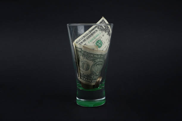 istock Dollar in a glass jar on black background 1127520947