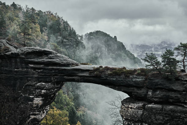 paisaje brumoso brumoso de pravcicka puerta (pravcicka brana) arco de la piedra arenisca natural más grande en europa en el parque nacional checa suiza (suiza bohemia o ceske svycarsko) - pravcicka fotografías e imágenes de stock