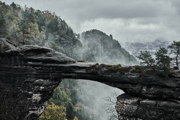 Misty foggy landscape of the Pravcicka gate (Pravcicka brana) the largest natural sandstone arch in Europe in Czech Switzerland (Bohemian Switzerland or Ceske Svycarsko) National Park Misty foggy landscape of the Pravcicka gate (Pravcicka brana) the largest natural sandstone arch in Europe in Czech Switzerland (Bohemian Switzerland or Ceske Svycarsko) National Park. pravcicka stock pictures, royalty-free photos & images